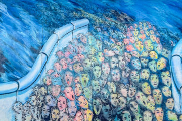 Personnes qui passent le mur de Berlin au format street art